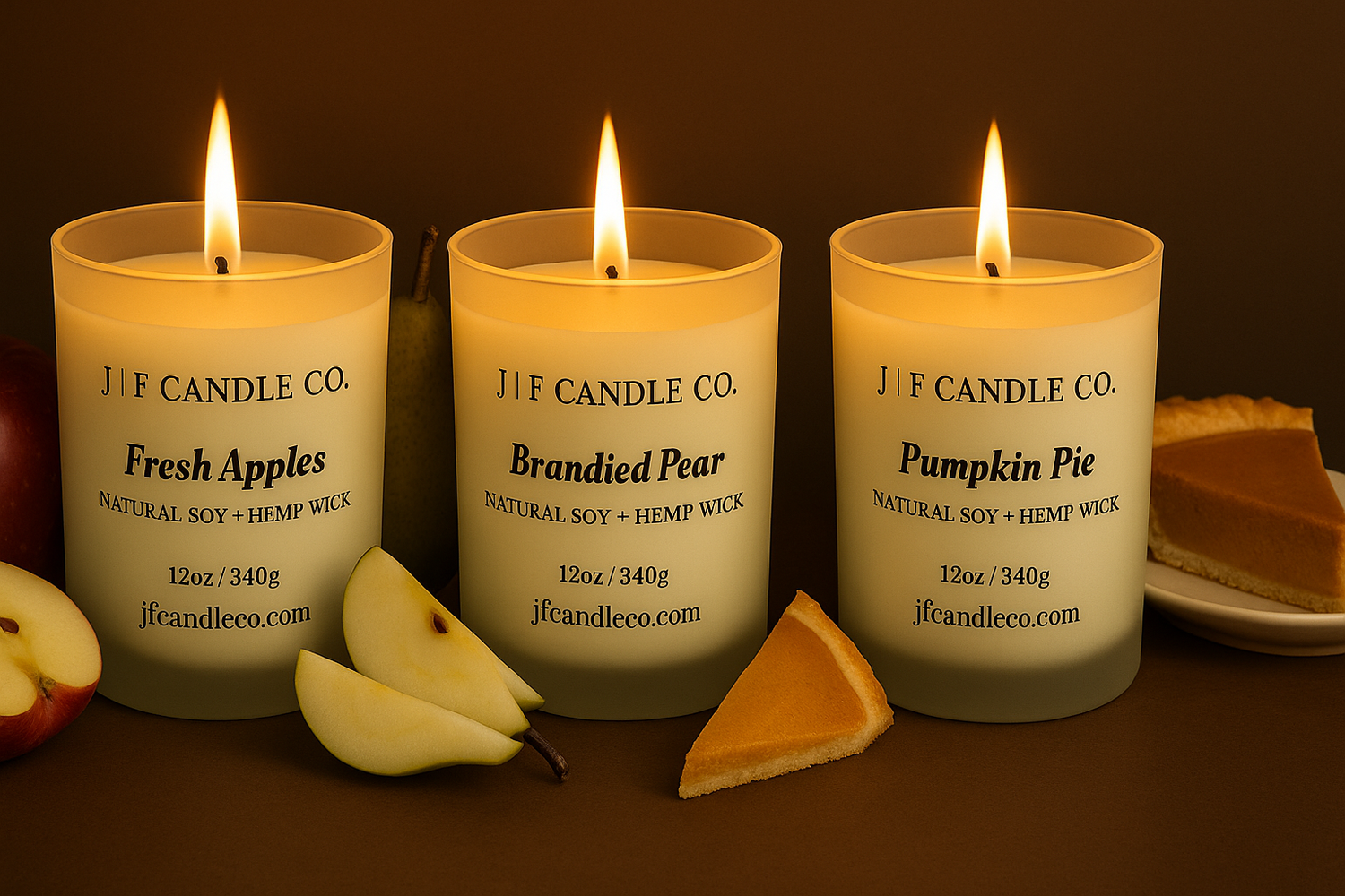 Three lit candles from J F Candle Co with fruit and pie slices on a dark background