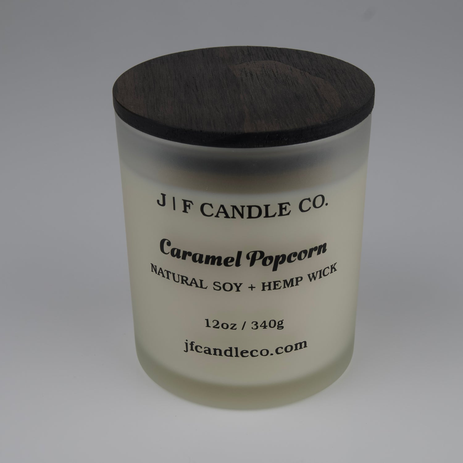Candle with a wooden lid labeled 'J/F Candle Co. Caramel Popcorn' on a white background