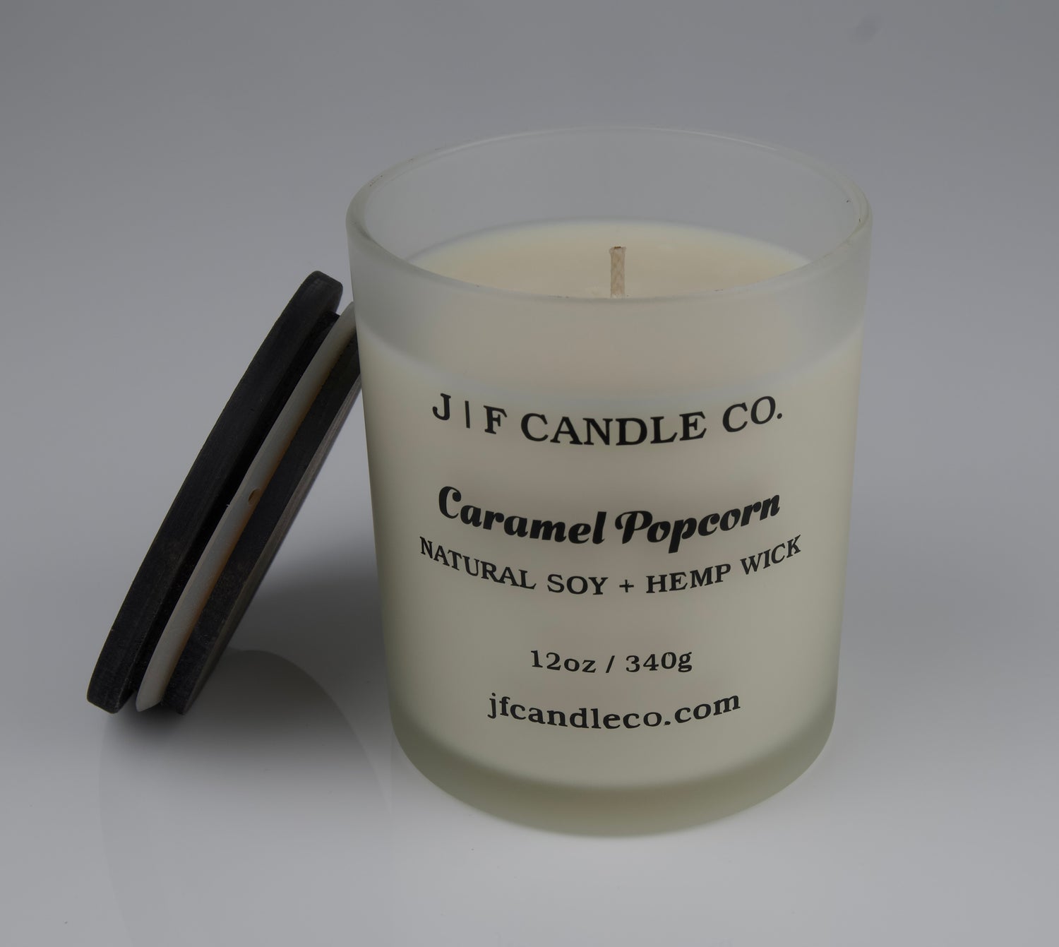 Candle with a brown wooden lid labeled 'J F Candle Co. Caramel Popcorn