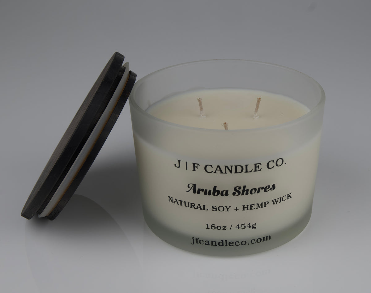 16oz Frosted candle jar with wooden lid jar labeled 'J/F Candle Co. Aruba Shores'