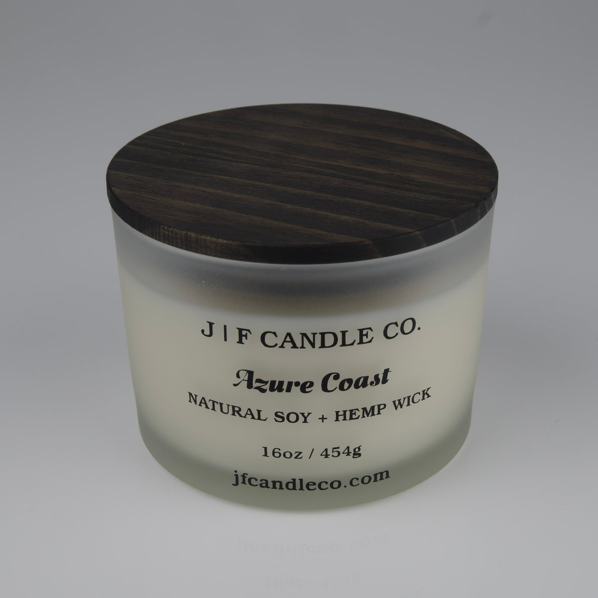 Candle jar with wooden lid labeled 'J/F Candle Co. Azure Coast' on a white background