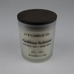 Frosted glass candle with wooden lid labeled 'J|F Candle Co. Caribbean Teakwood'