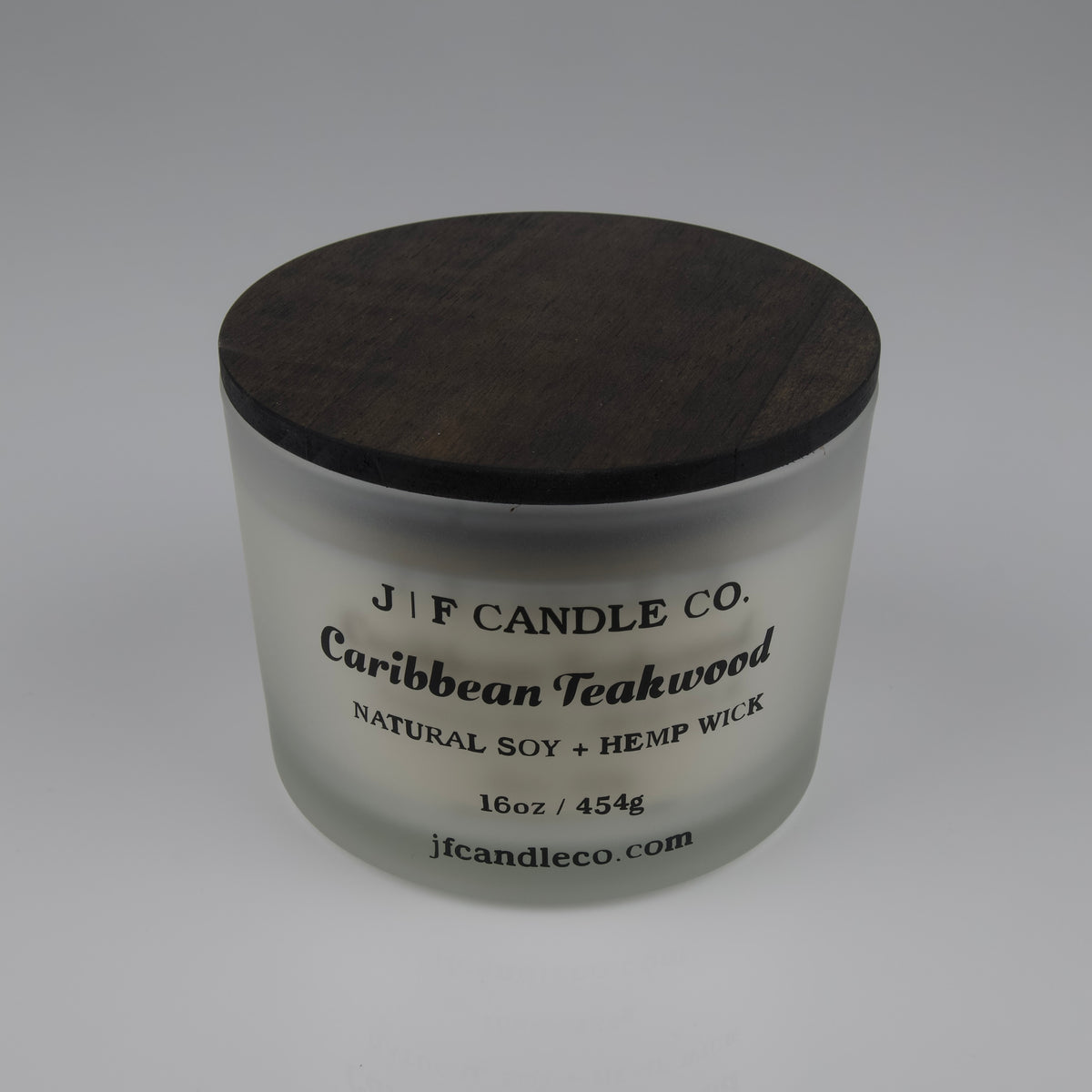 16oz Frosted glass candle with wooden lid labeled 'J|F Candle Co. Caribbean Teakwood'