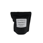 A black resealable stand-up pouch with a white label reading 'JF CANDLE CO.' and 'Caramel Popcorn' on a plain white background.