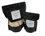 Two black candle bags with labels from J/F Candle Co on a gray background