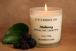 Luxury Mulberry soy candle by J | F Candle Co. with a glowing flame, surrounded by fresh mulberries on a warm background, natural soy and hemp wick, eco-friendly handmade candle for a cozy and elegant home fragrance.