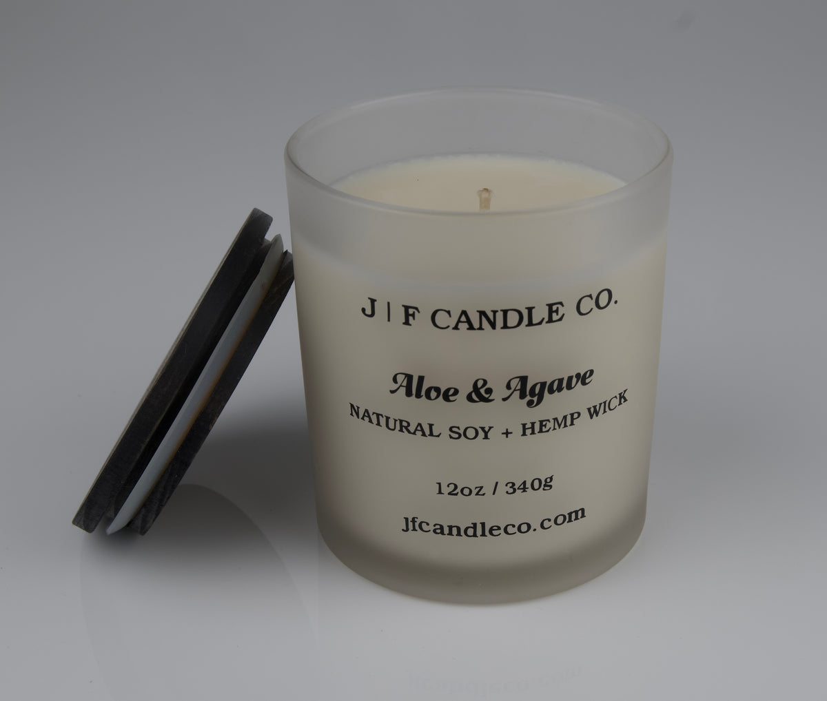 JF Candle Co. 12oz Aloe and Agave soy candle with single hemp wick in frosted glass jar, dark wooden lid resting beside it.