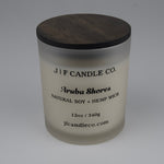 Frosted candle jar with wooden lid labeled 'J/F Candle Co. Aruba Shores'