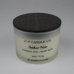 Frosted candle jar with wooden lid labeled 'J|F Candle Co. Amber Noir' on a white background