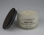 Candle with a brown lid labeled 'JF Candle Co. Amber Noir'