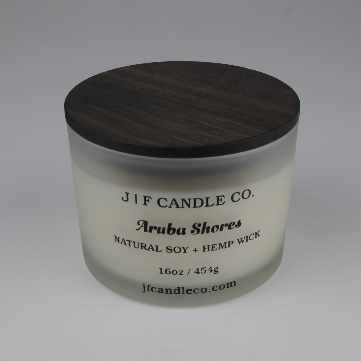 Candle jar with wooden lid labeled 'J/F Candle Co. Aruba Shores' 