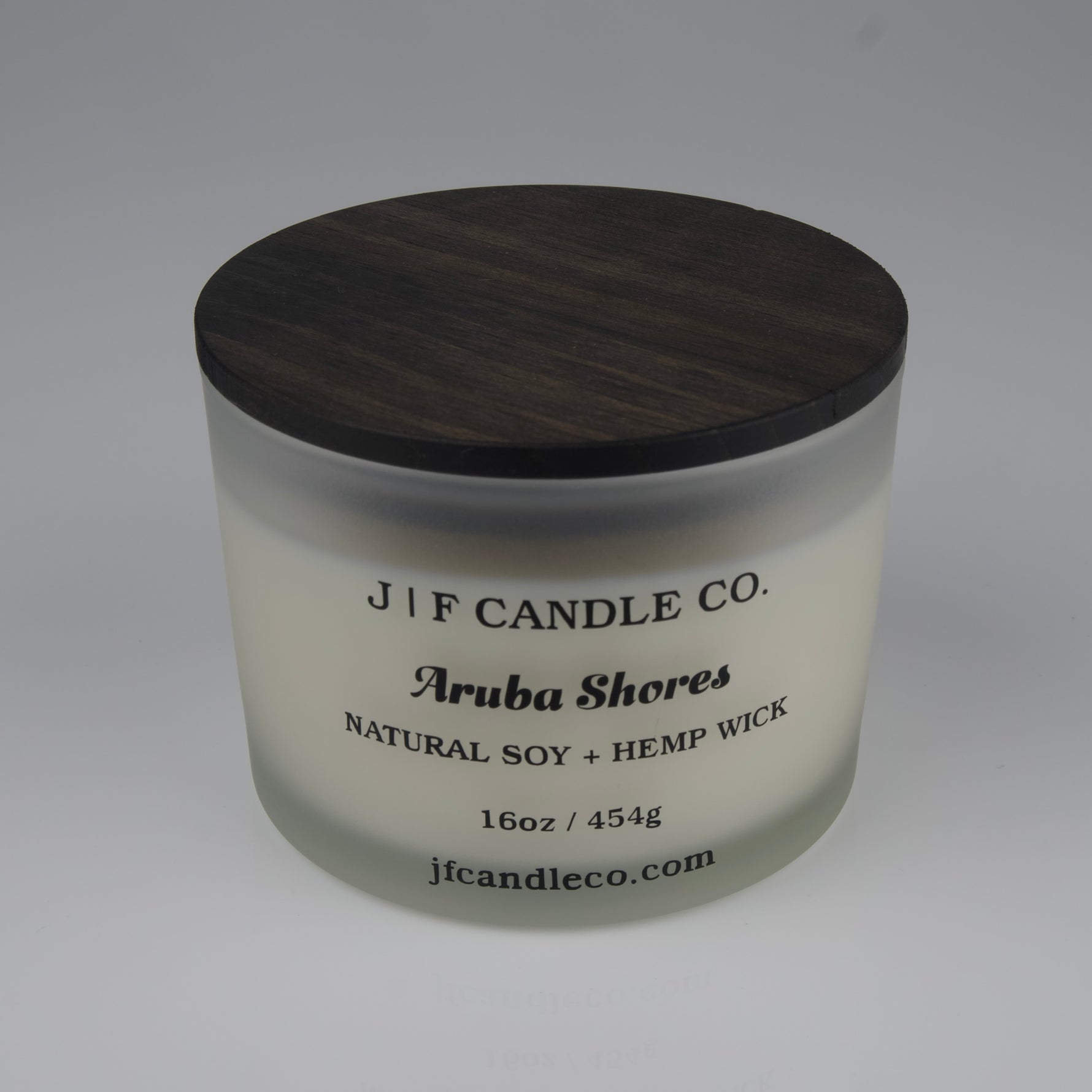 Candle jar with wooden lid labeled 'J/F Candle Co. Aruba Shores' 
