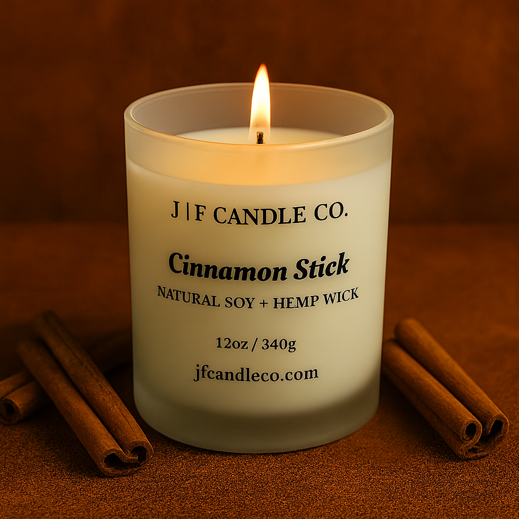 Candle with cinnamon sticks on a brown background, featuring J|F Candle Co. branding.