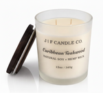 J | F Candle Co. Caribbean Teakwood 12 oz natural soy candle in frosted glass jar with lid off on clean white background with soft reflection
