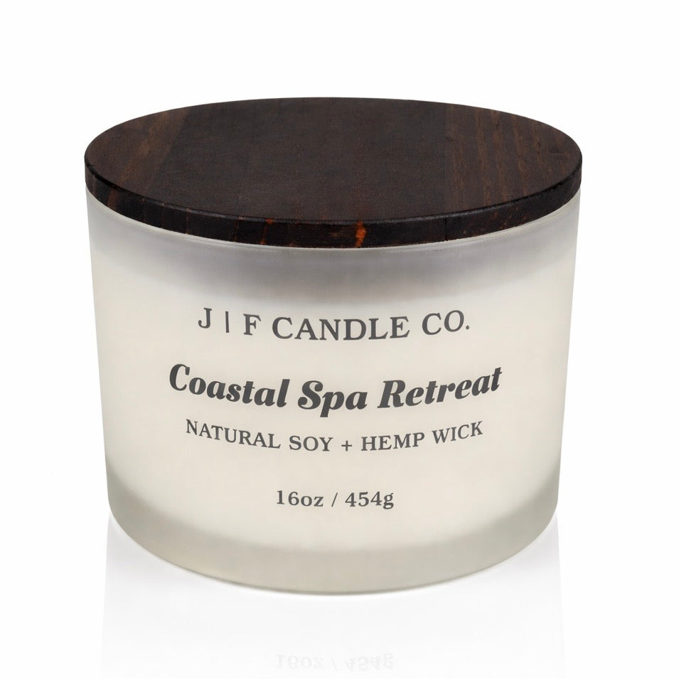 16oz Coastal Spa Retreat soy candle by J | F Candle Co. in a frosted glass jar with a wooden lid, clean white background product photo.