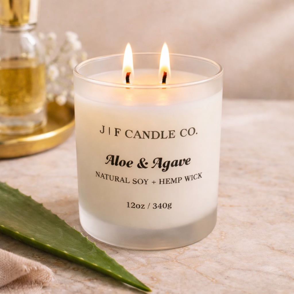 J | F Candle Co Aloe & Agave luxury soy candle with double wick burning on marble surface, styled with aloe leaf and warm spa-inspired lighting