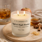 J | F Candle Co. Apple & Maple Bourbon 12 oz natural soy candle lit with apple, bourbon glass, maple syrup and warm fall styling