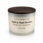 JF Candle Co. Apple & Maple Bourbon 16oz soy candle in a frosted glass jar with wooden lid, clean studio background and soft reflective surface.