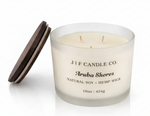 Luxury frosted glass J | F Candle Co. Aruba Shores soy candle with wooden lid resting beside the jar and a soft reflection beneath on a clean white background.