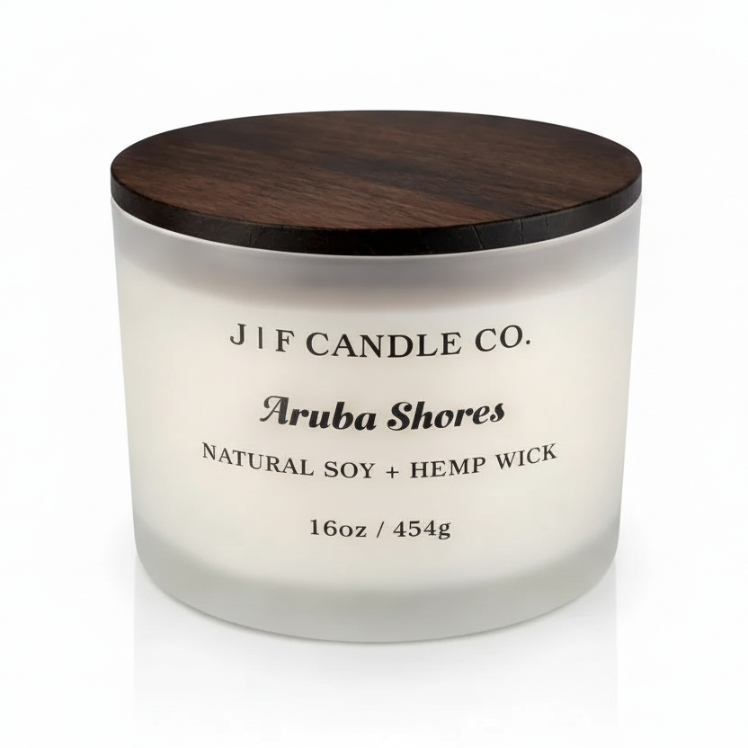 Luxury frosted glass Aruba Shores soy candle with wooden lid, soft reflection beneath jar, clean white background.