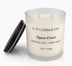 Luxury frosted glass soy candle labeled “Azure Coast” by J | F Candle Co., shown with wooden lid beside the jar and a soft reflective base on a clean white background.