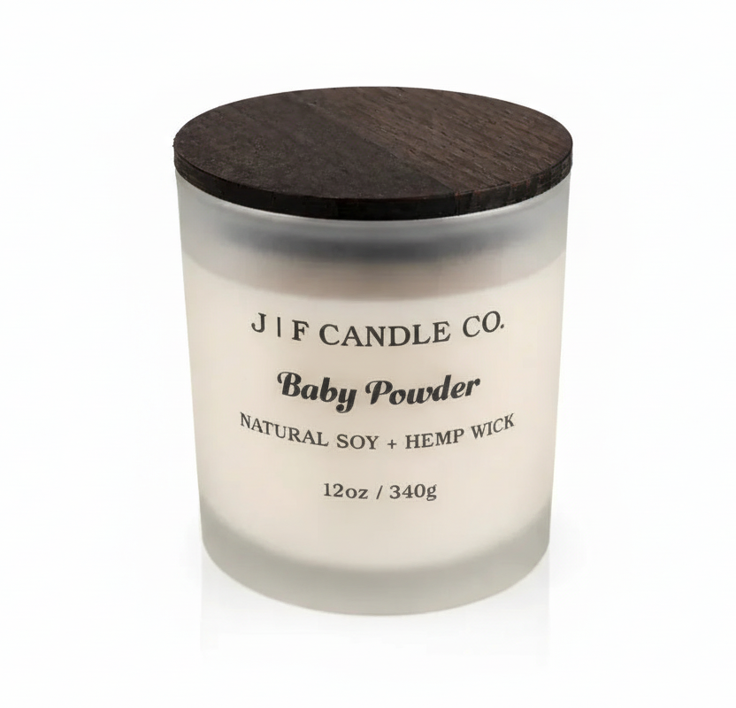 “J | F Candle Co. Baby Powder 12oz frosted glass soy candle with wooden lid on a clean background with soft reflection.”
