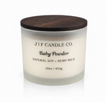 J | F Candle Co. Baby Powder 16oz soy candle in frosted glass jar with wooden lid and soft reflection on a clean white background.