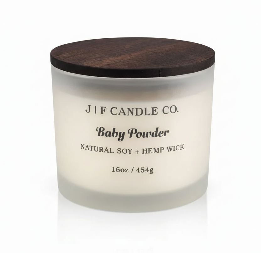 J | F Candle Co. Baby Powder 16oz soy candle in frosted glass jar with wooden lid and soft reflection on a clean white background.