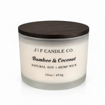 J F Candle Co Bamboo & Coconut 16 oz soy candle in a frosted glass jar with wooden lid on a clean white background with soft reflection