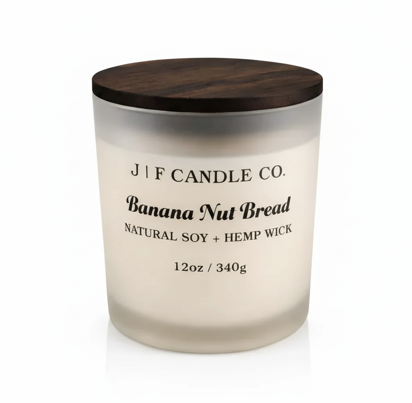 J F Candle Co Banana Nut Bread 12 oz soy candle in a frosted glass jar with wooden lid on a clean white background with soft reflection