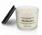 J | F Candle Co. Blue Hawaiian 16 oz luxury soy candle in frosted glass jar with wooden lid beside candle