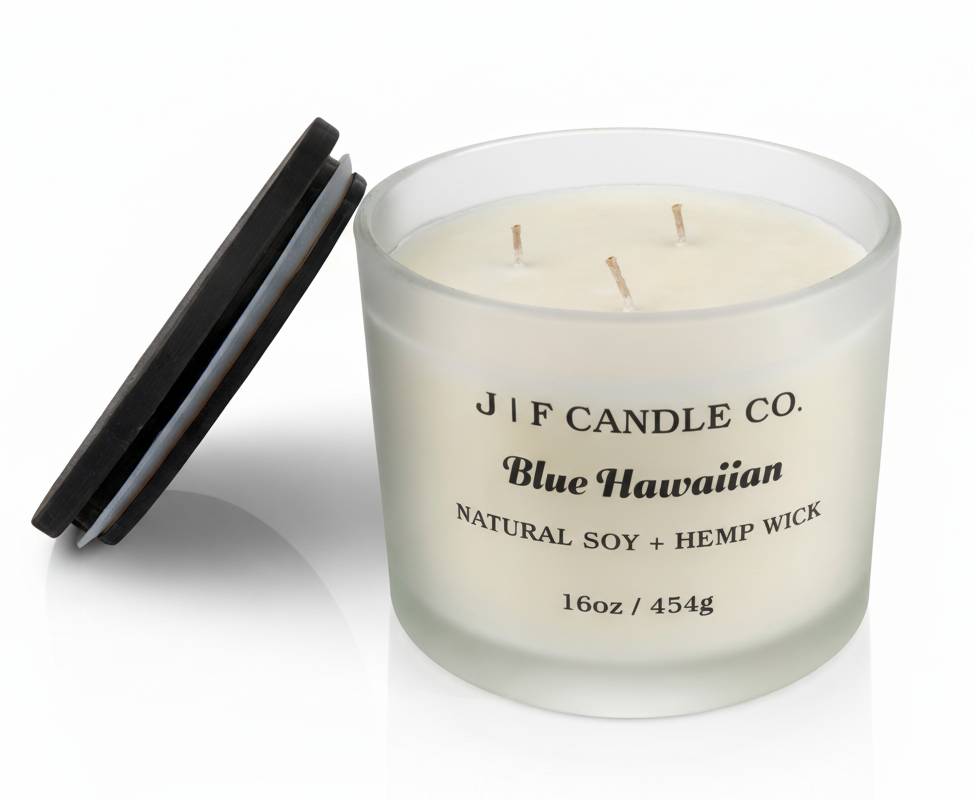 J | F Candle Co. Blue Hawaiian 16 oz luxury soy candle in frosted glass jar with wooden lid beside candle