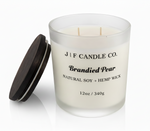 J | F Candle Co. Brandied Pear 12 oz natural soy candle in frosted glass jar with wooden lid beside candle on clean white background