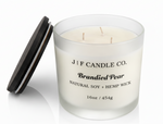 J | F Candle Co. Brandied Pear 16 oz natural soy candle with three wicks in frosted glass jar and wooden lid beside candle on white background