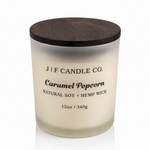 J | F Candle Co. Caramel Popcorn 12 oz natural soy candle in frosted glass jar with wooden lid and soft reflection on clean white background