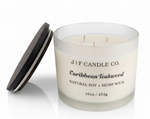 J | F Candle Co Caribbean Teakwood 16 oz soy candle in frosted glass jar with three wicks and wooden lid beside jar on clean white background with soft reflection