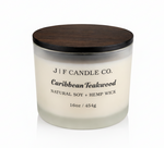 J | F Candle Co Caribbean Teakwood 16 oz soy candle in frosted glass jar with wooden lid on clean white background with soft reflection