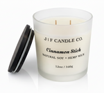 J | F Candle Co. Cinnamon Stick 12oz soy candle in frosted glass jar with wooden lid placed beside it on a clean white background with soft reflection