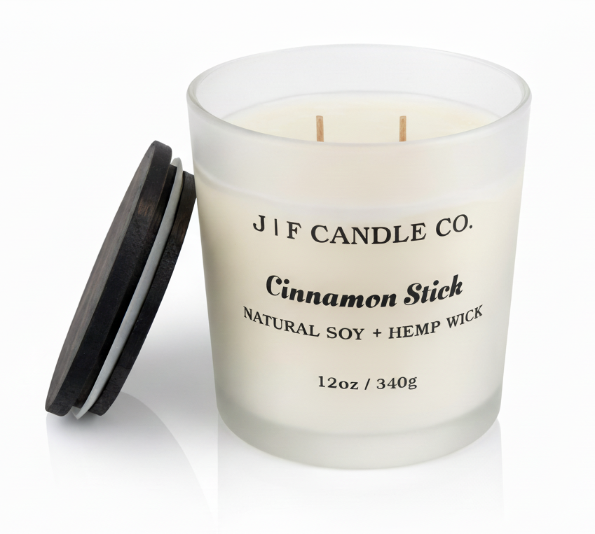 J | F Candle Co. Cinnamon Stick 12oz soy candle in frosted glass jar with wooden lid placed beside it on a clean white background with soft reflection