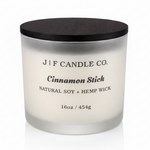 J | F Candle Co. Cinnamon Stick 16oz soy candle in frosted glass jar with wooden lid on a clean white background with soft reflection