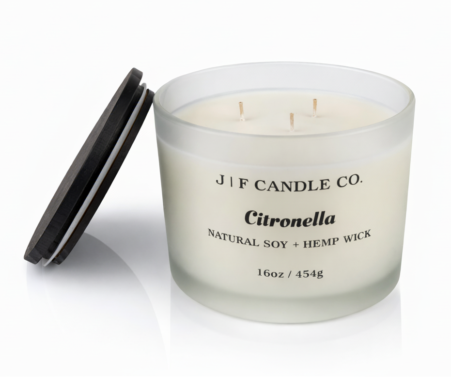 J | F Candle Co. Citronella 16oz triple wick soy candle in frosted glass jar with wooden lid placed beside it on a clean white background with soft reflection