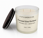 J | F Candle Co. Coconut Lime Verbena 12oz soy candle in frosted glass jar with wooden lid placed beside it on a clean white background with soft reflection