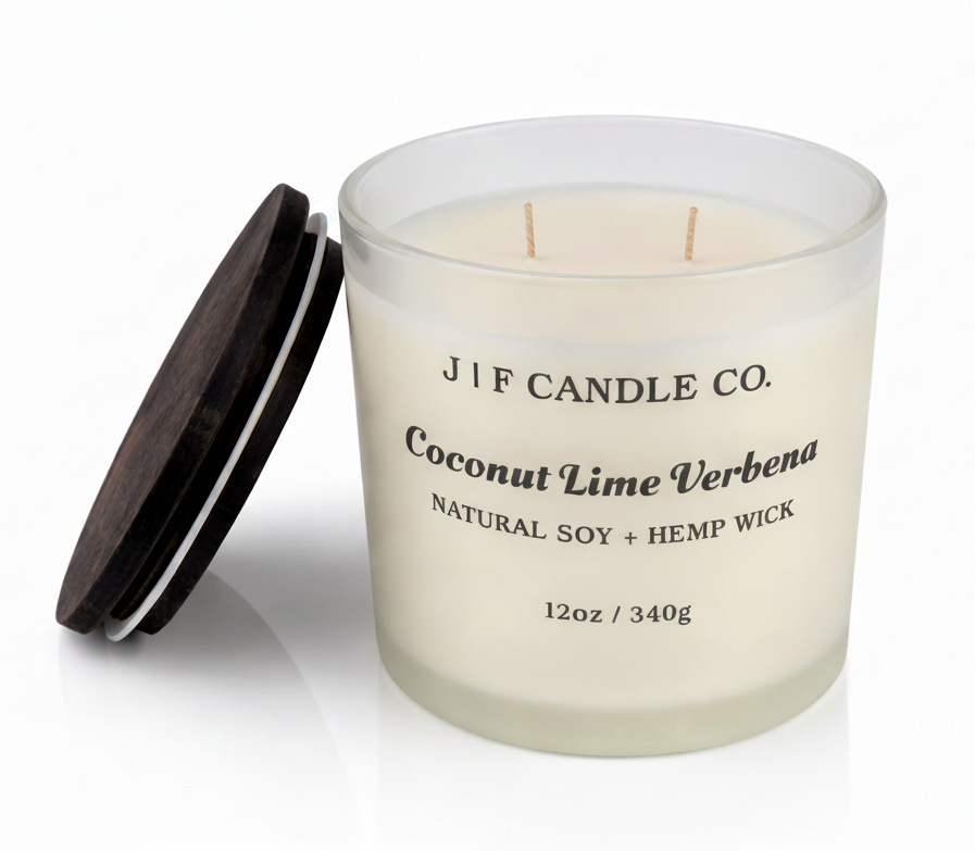 J | F Candle Co. Coconut Lime Verbena 12oz soy candle in frosted glass jar with wooden lid placed beside it on a clean white background with soft reflection