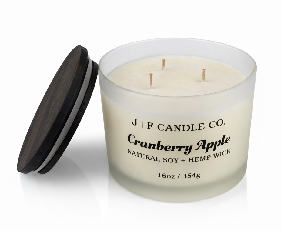 J | F Candle Co Cranberry Apple 16oz three wick soy candle with wooden lid beside candle on white background with soft reflection