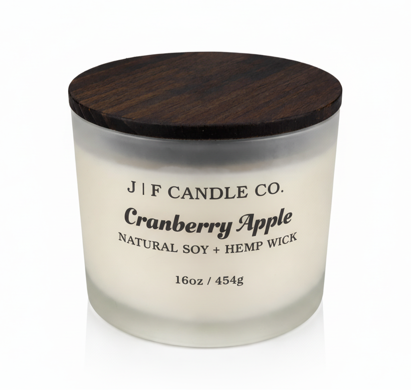 J | F Candle Co Cranberry Apple 16oz soy candle in frosted glass jar with wooden lid on white background with soft reflection