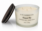 J | F Candle Co Fraser Fir 16oz three wick soy candle in frosted glass jar with wooden lid beside candle on white background with soft reflection