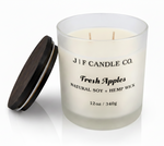 J | F Candle Co Fresh Apples soy candle in frosted glass jar with wooden lid beside it, clean white background with soft reflection, 12oz hemp wick candle