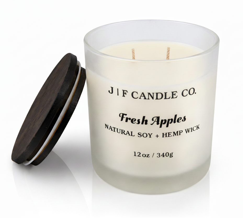 J | F Candle Co Fresh Apples soy candle in frosted glass jar with wooden lid beside it, clean white background with soft reflection, 12oz hemp wick candle