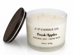J | F Candle Co Fresh Apples 16oz three-wick soy candle in frosted glass jar with wooden lid beside it, clean white background with soft reflection