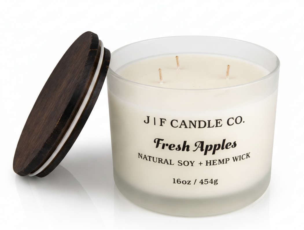 J | F Candle Co Fresh Apples 16oz three-wick soy candle in frosted glass jar with wooden lid beside it, clean white background with soft reflection